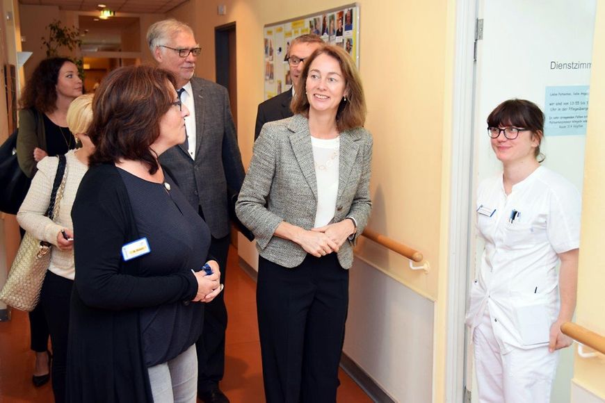 Bundesfamilienministerin Dr. Katarina Barley gemeinsam mit Pflegepersonal auf dem Flur des Lazarus Hospiz.