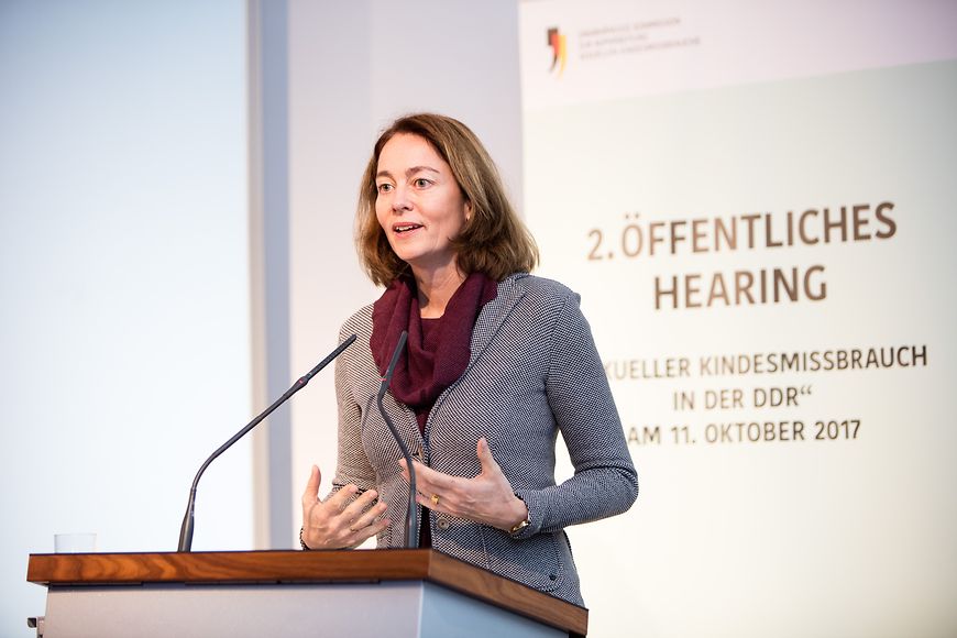 Katarina Barley am Rednerpult im Hintergrunf ein Plakat: 2. Öffentliches Hearing Sexueller Kindesmissbrauch in der DDR