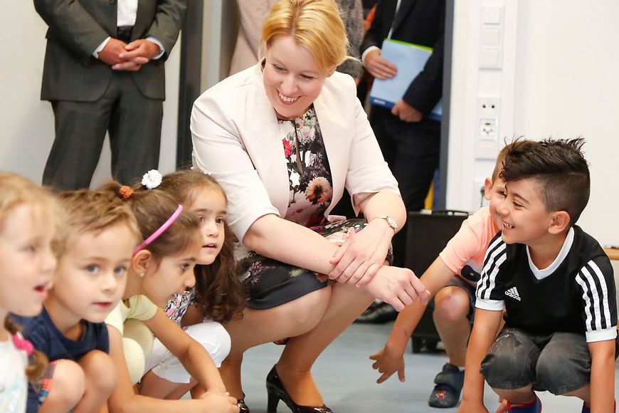 Bundesfamilienministerin Dr. Franziska Giffey auf dem Boden kniend in einer Gruppe von Kindern