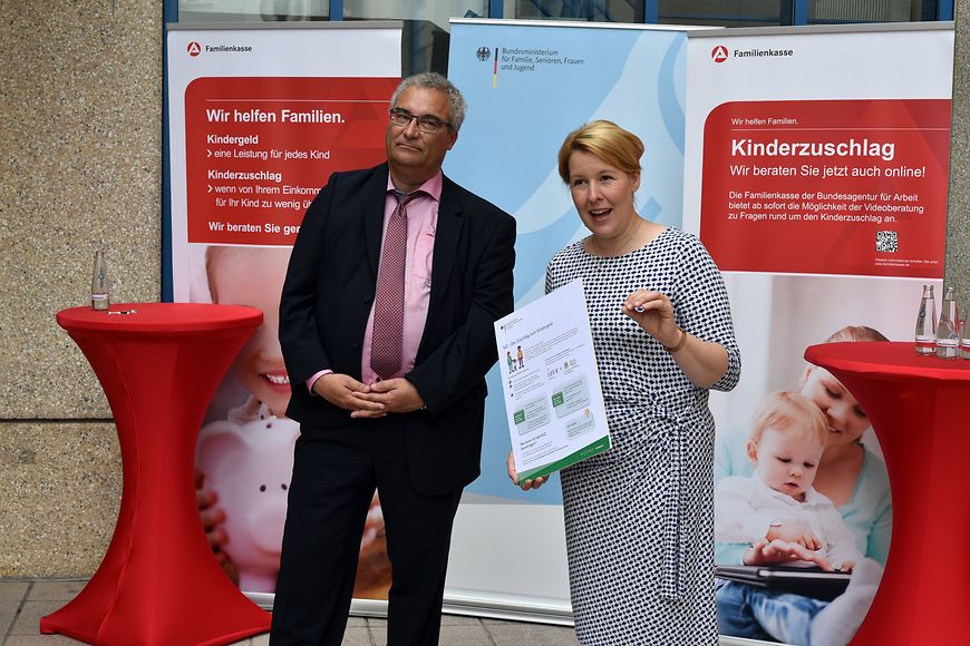 Dr. Franziska Giffy und Karsten Bunk vor Aufstellern zum Thema Kinderzuschlag und Kindergeld der Familienkasse