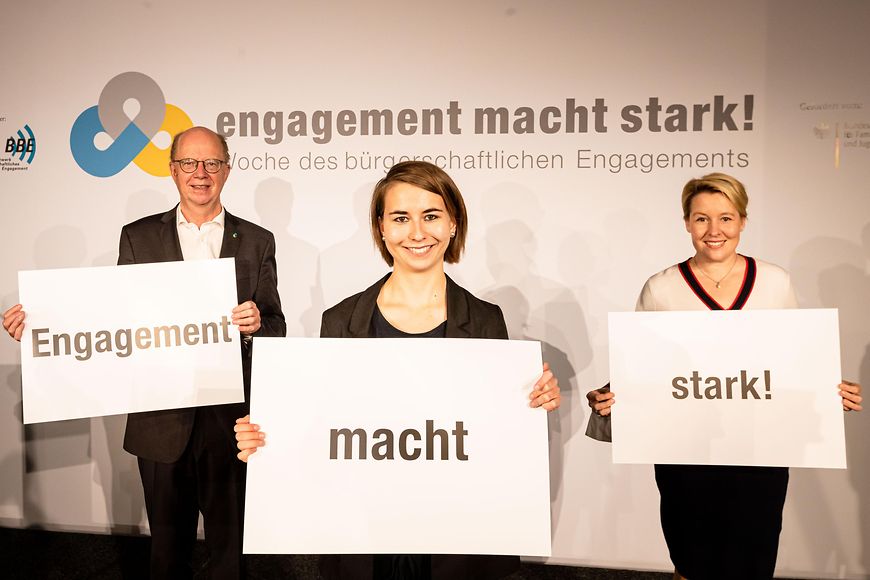 Dr. Thomas Röbke, Dr. Franziska Giffey und Annalena Stöger halten die Schilder hoch: Engagement macht stark!