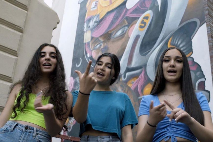 Drei Mädchen vor einer Graffitiwand