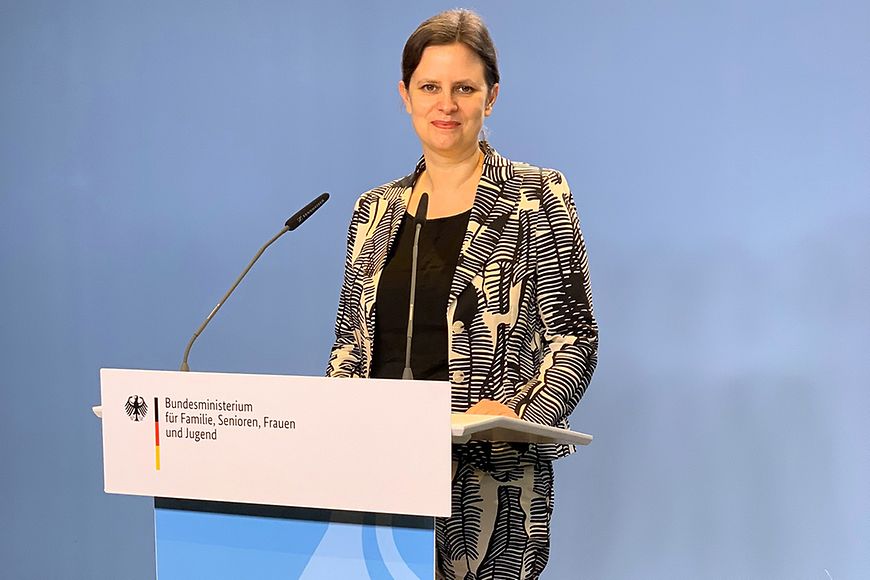 Juliane Seifert am Redepult im Bundesgleichstellungsministerium vor einer blauen Wand