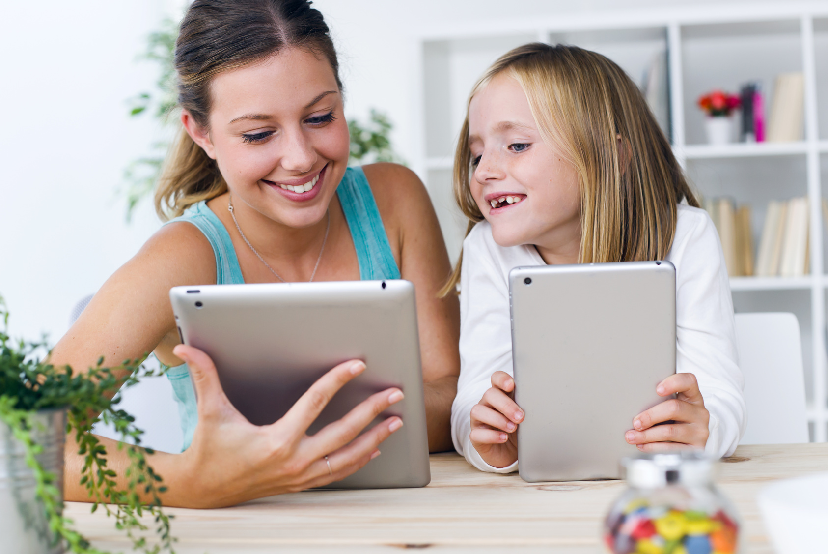 Mutter und Tochter spielen mit Tablets