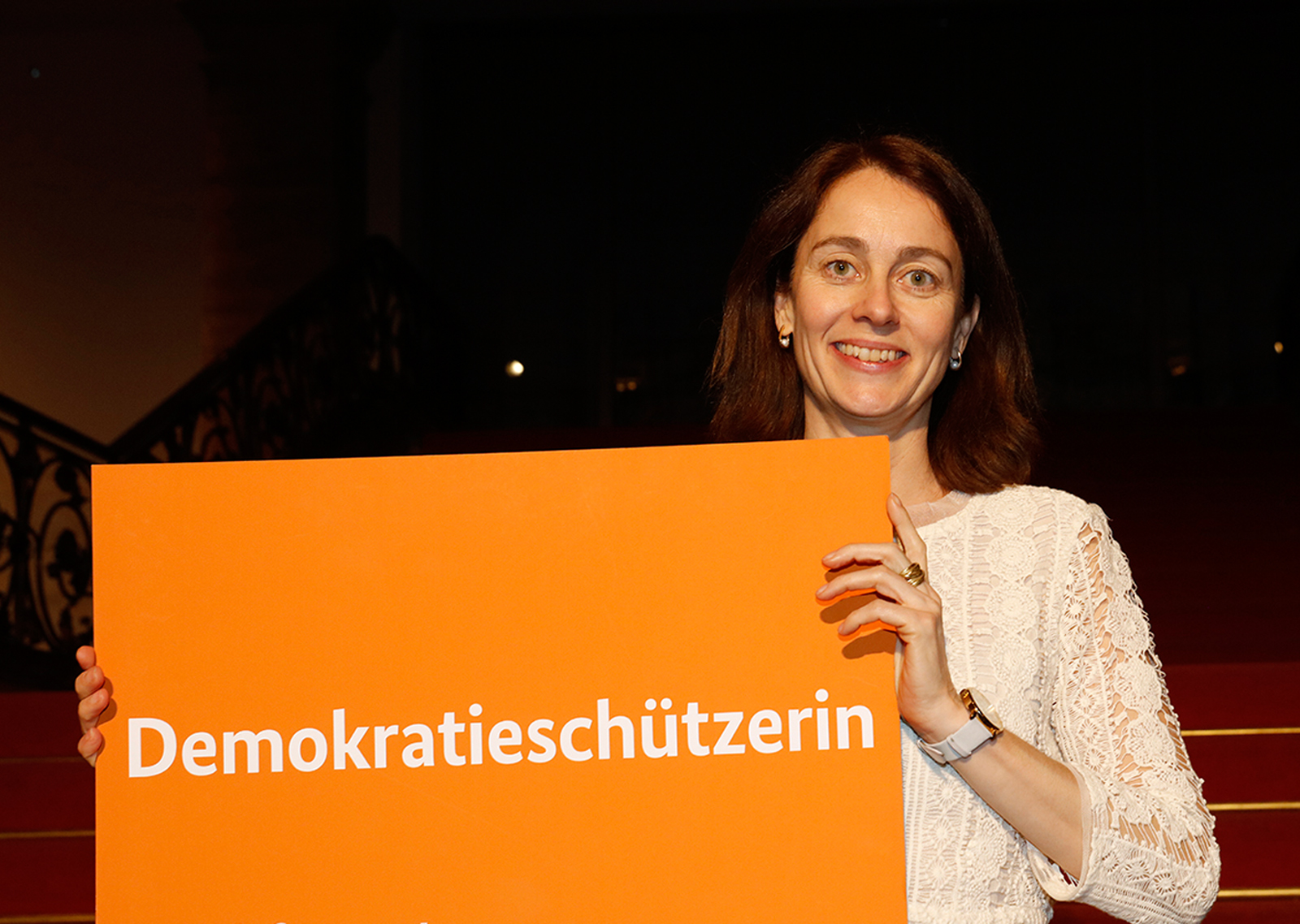 Katarina Barley mit einem Schild "Demokratieschützerin"