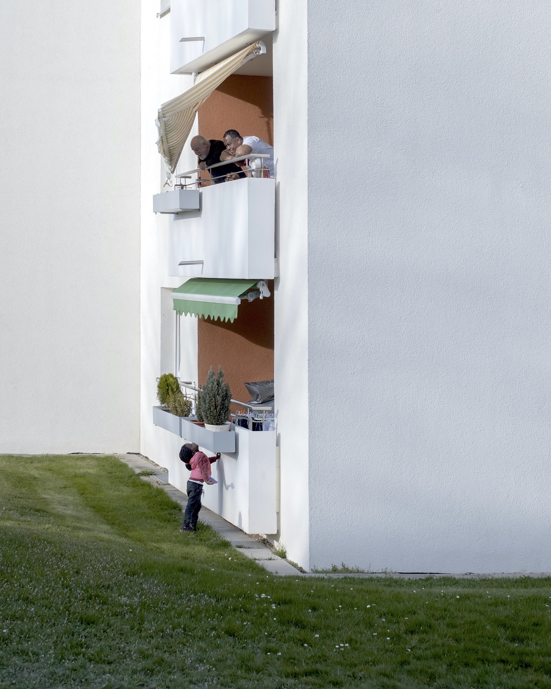 Ein Kind steht unten vor einem Mietshaus - Deutscher Jugendfotopreis 2022
