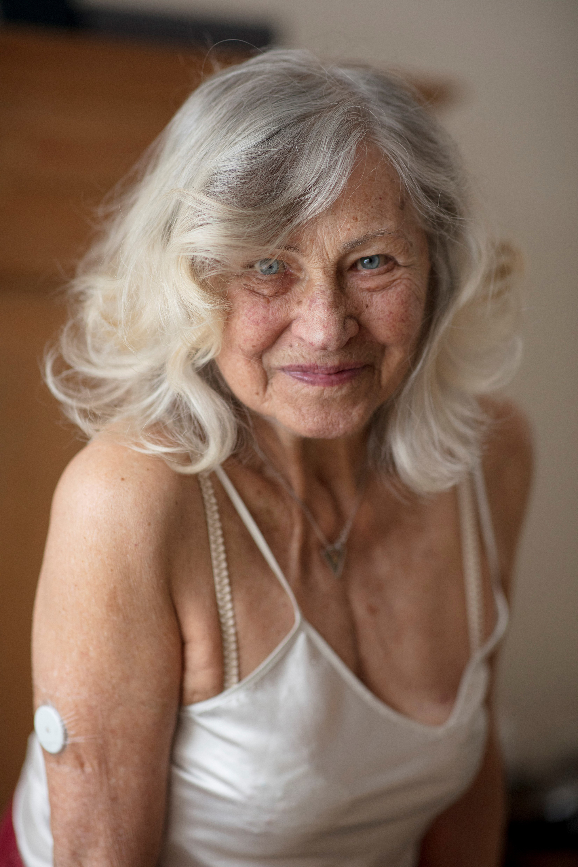 Eine ältere Frau mit grauen Haaren und weißem Top