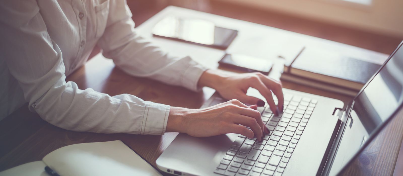 Eine Frau tippt auf einer Laptop-Tastatur