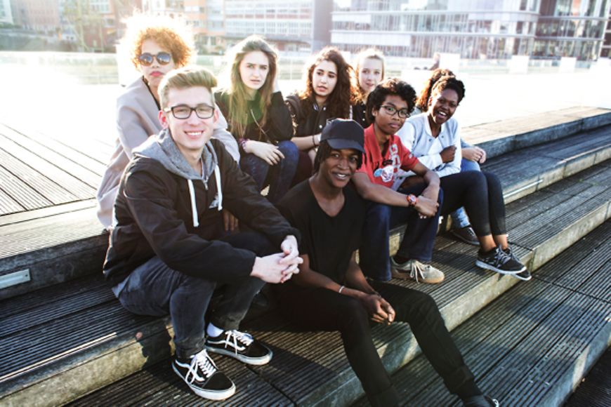 Junge Menschen sitzen zusammen im Freien