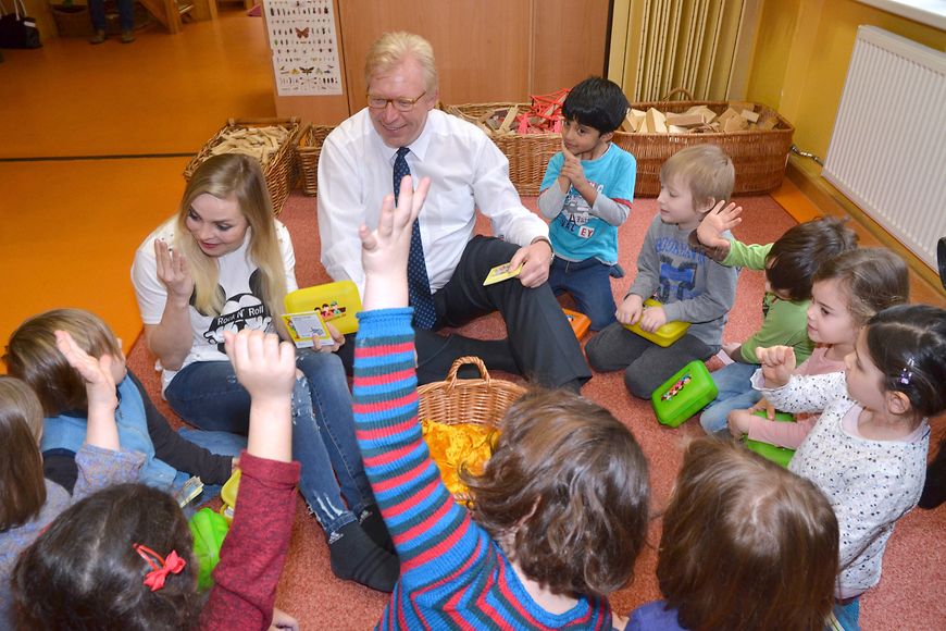 Staatssekretär Dr. Ralf Kleindiek und Regina Halmich sitzen mit Kindern einer Berlin Kita im Kreis.