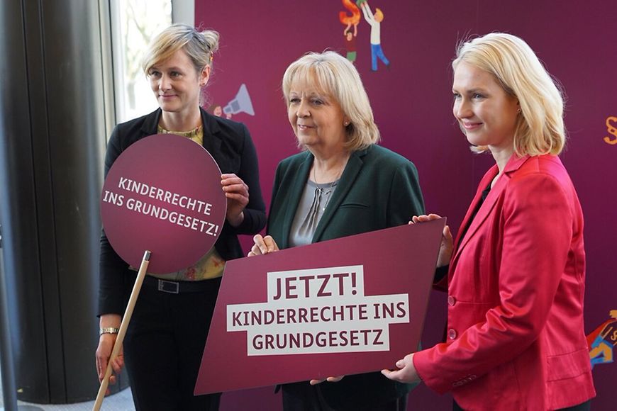 Manuela Schwesig, Hannelore Kraft und Christina Kampmann halten Schilder mit der Aufschrift "Kinderrechte ins Grundgesetz"