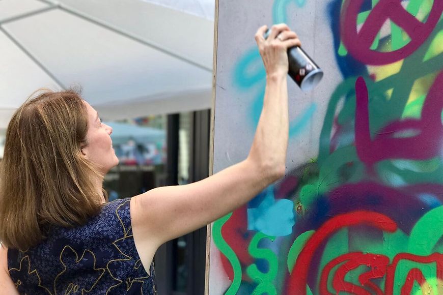 Katarina Barley besprüht eine eigens dafür aufgestellte Wand