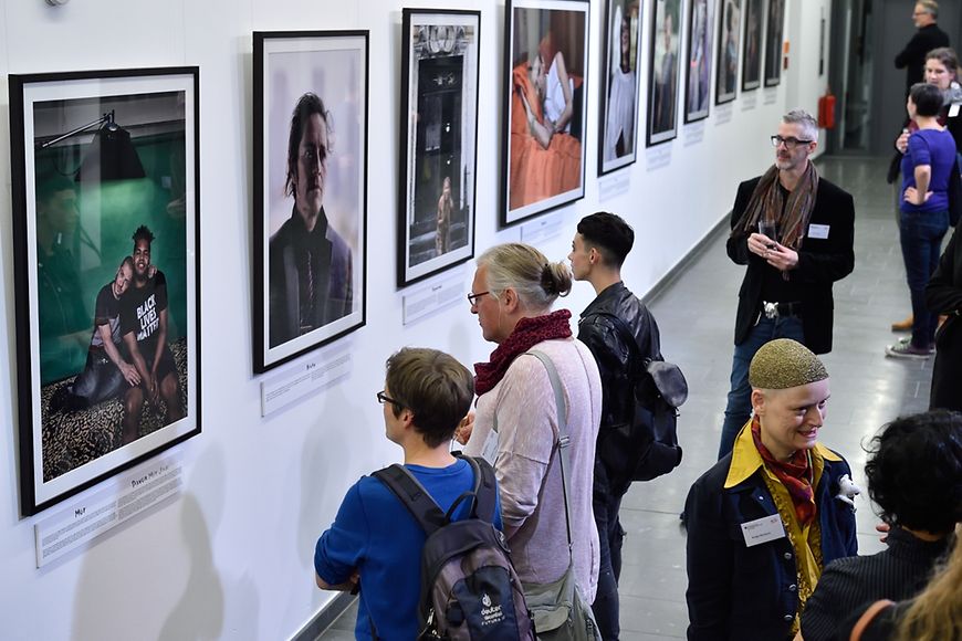 Die Gäste schauen sich die Bilder der Ausstellung "All the people" an.