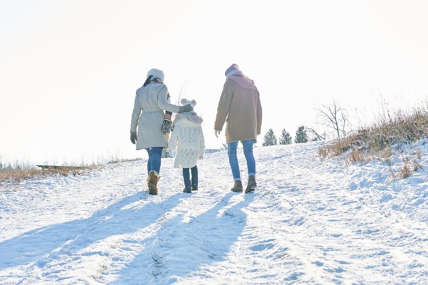 Familie von hinten in schneebedeckter Landschaft