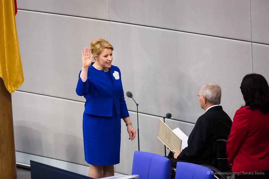 Dr. Franziska Giffey steht mit erhobener Hand vor dem Bundestagspräsidenten