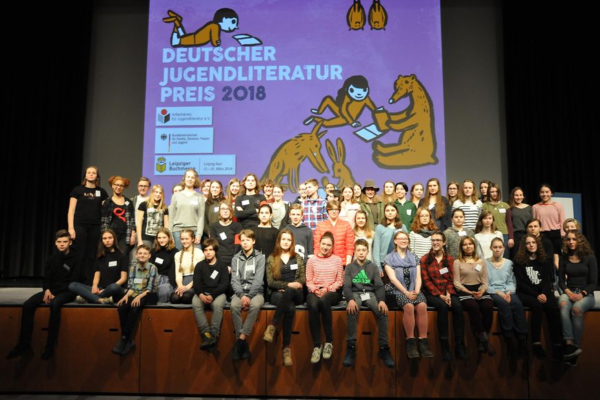 Ein Gruppenbild der Jugendjury des Deutschen Jugendliteraturpreises auf einer Bühne sitzend 