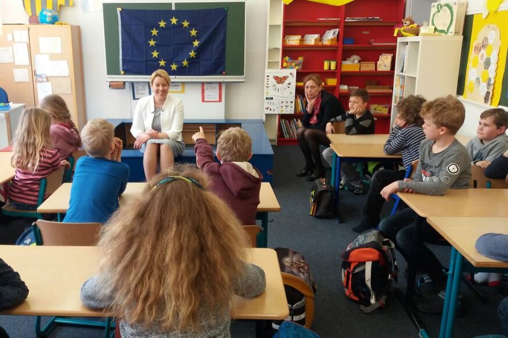 Franziska Giffey sitzt in einem Klassenzimmer vor einer Kindergruppe