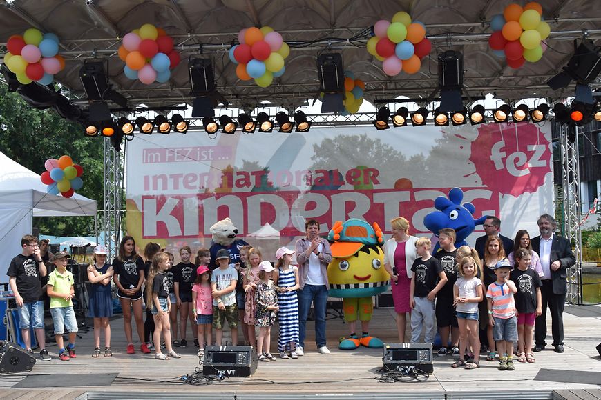 Das Bild zeigt Franziska Giffey inmitten einer Kindergruppe auf der Bühne