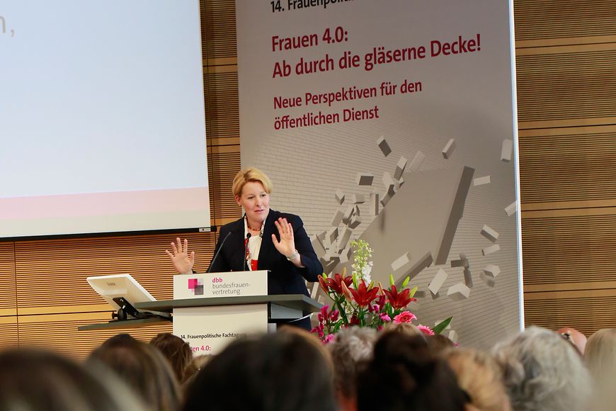 Die Ministerin steht an einem Rednerpult vor Publikum und spricht