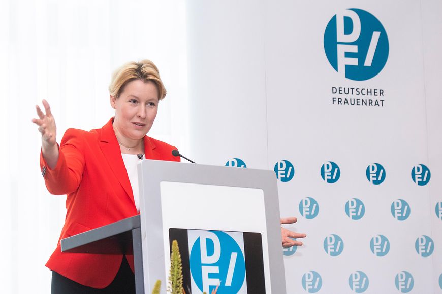 Die Familienministerin steht an einem Rednerpult und spricht. Im Hintergrund ist das Logo des Deutschen Frauenrats zu sehen.