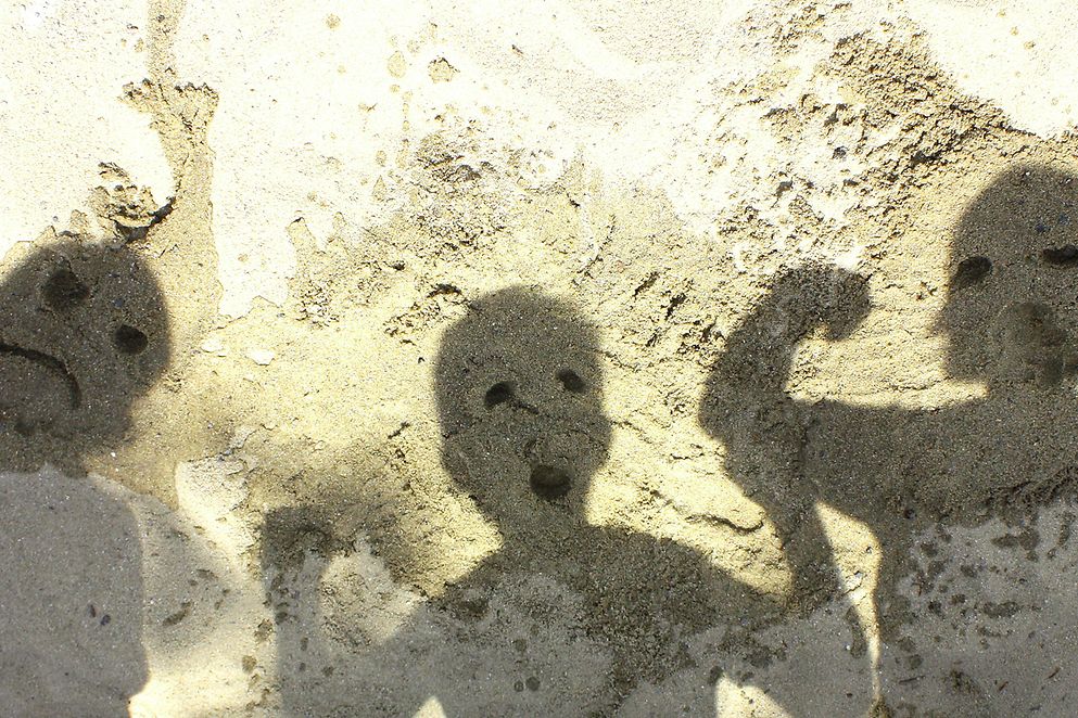 Das Bild zeigt Schatten von Kindern an einer Hauswand