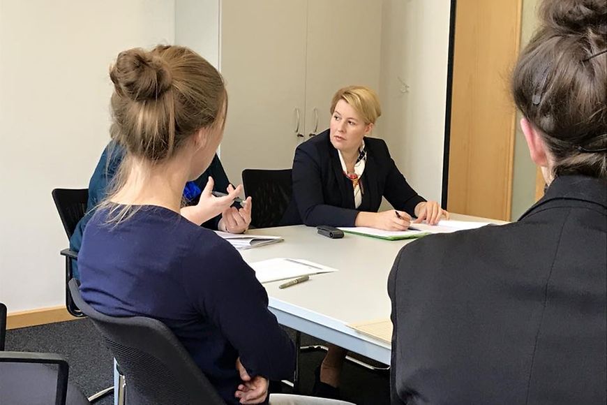 Das Bild zeigt Dr. Franziska Giffey im Gespräch mit Meschen an einem Tisch