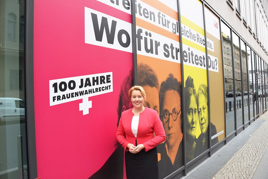 Das Bild zeigt Dr. Franziska Giffey vor der beklebten Fassade des Bundesfrauenministeriums
