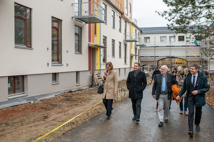 Das Bild zeigt Stefan Zierke mit einer Gruppe Menschen an Häusern entlanglaufend