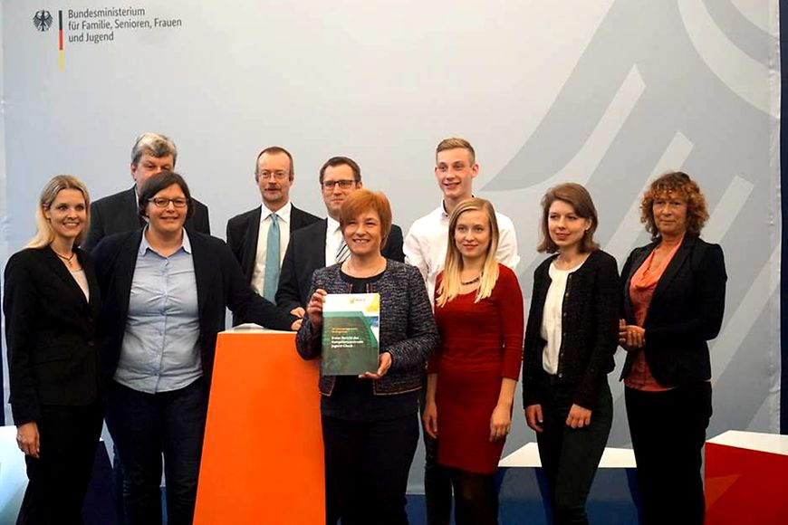 Das Bild zeigt Caren Marks mit einer Broschüre in der Hand, umgeben von mehreren Menschen
