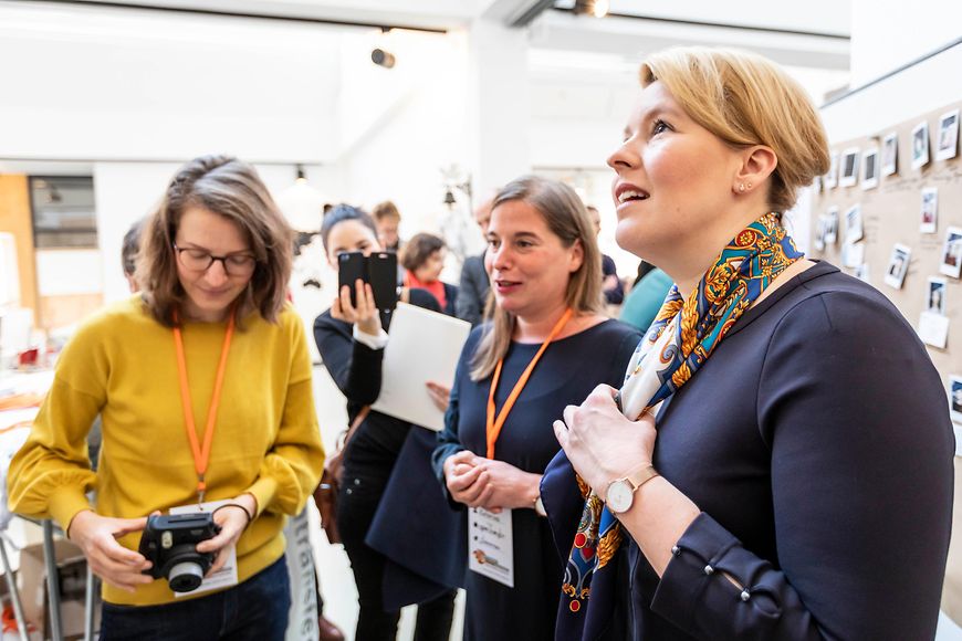 Das Bild zeigt Dr. Franziska Giffey bei einem Rundgang durch das Barcamp, zwei Frauen erklären ihr dabei etwas