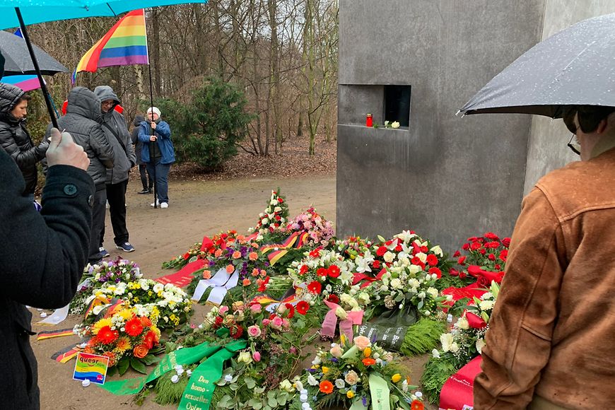 Das Bild zeigt Kränze vor dem Denkmal für die im Nationalsozialismus verfolgten Homosexuellen in Berlin 