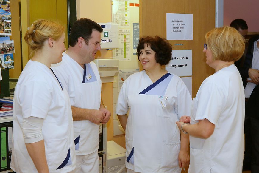 Das Bild zeigt Franziska Giffey und Hubertus Heil im Gespräch mit zwei Pflegerinnen