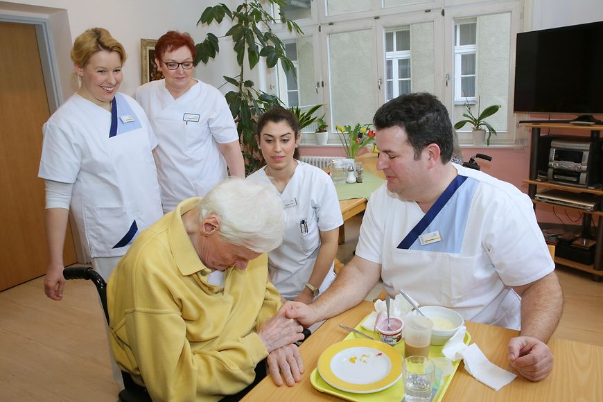 Das Bild zeigt Franziska Giffey und Hubertus Heil mit zwei Pflegerinnen und einem älteren Herrn im Speisesaal