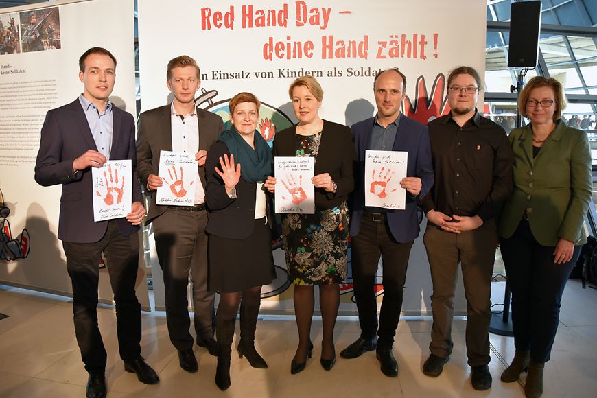 Das Bild zeigt Dr. Franziska Giffey mit mehreren Personen, die weiße Blätter mir roten Handabdrücken zeigen