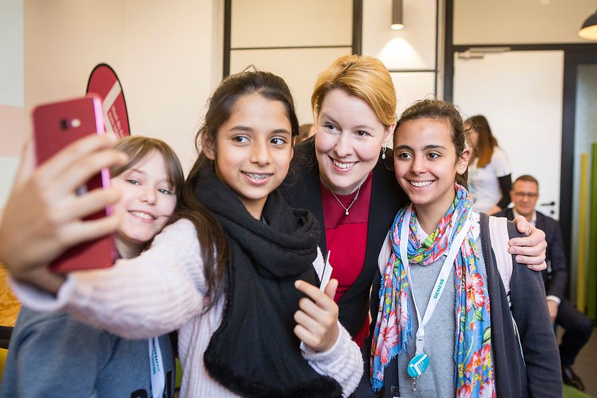 Das Bild zeigt Franziska Giffey mit zwei Mädchen, die mit ihr ein Foto machen