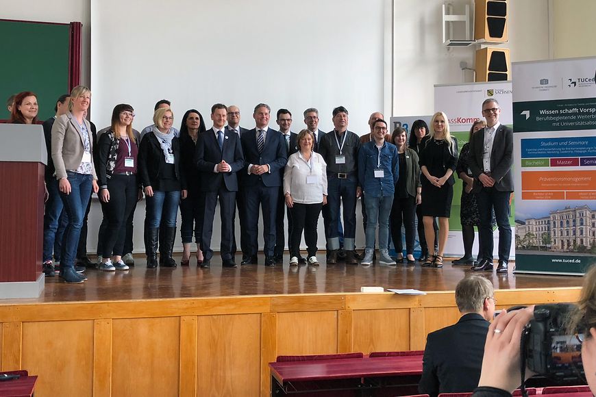 Das Bild zeigt eine Gruppe von Menschen im Hörsaal, unter anderem mit Stefan Zierke und Michael Kretschmer
