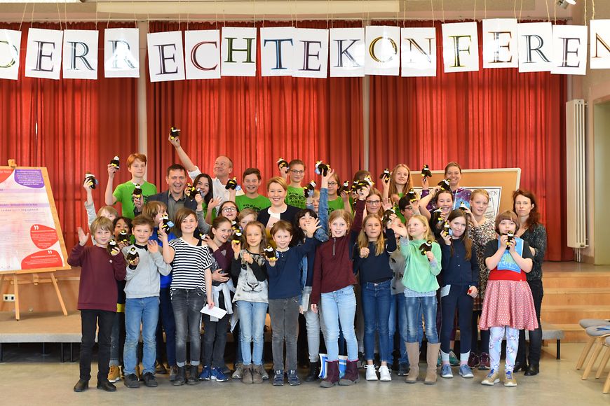 Das Bild zeigt Dr. Franziska Giffey mit Kindern für ein Gruppenbild posierend