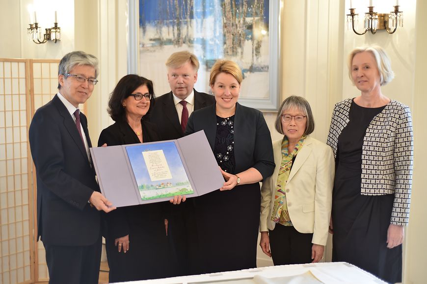Das Bild zeigt Franziska Giffey und den japanischen Botschafter, die eine Urkunde in der Hand halten
