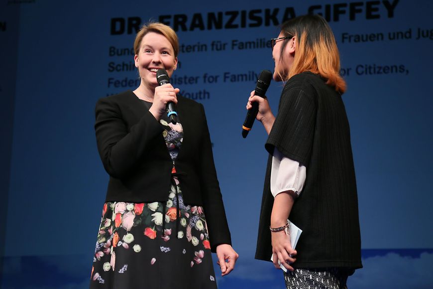 Franziska Giffey und die Moderatorin des Festivals stehen mit Mikrofon auf der Bühne