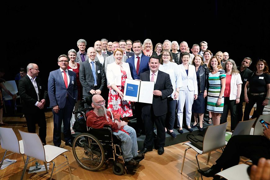 Das Bild zeigt Dr. Franziska Giffey mit Jens Spahn und Hubertus Heil auf einem Podium