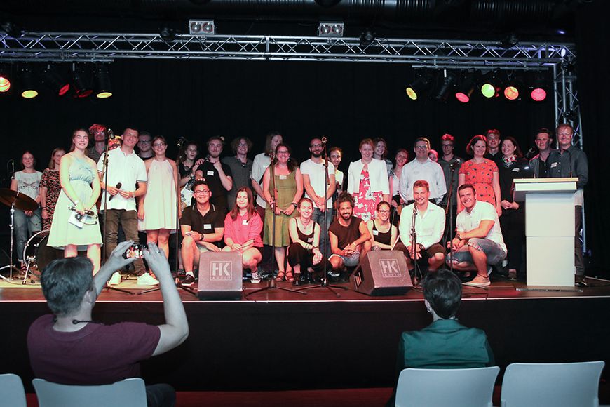 Eine Gruppe von Menschen auf einer Bühne am Abend