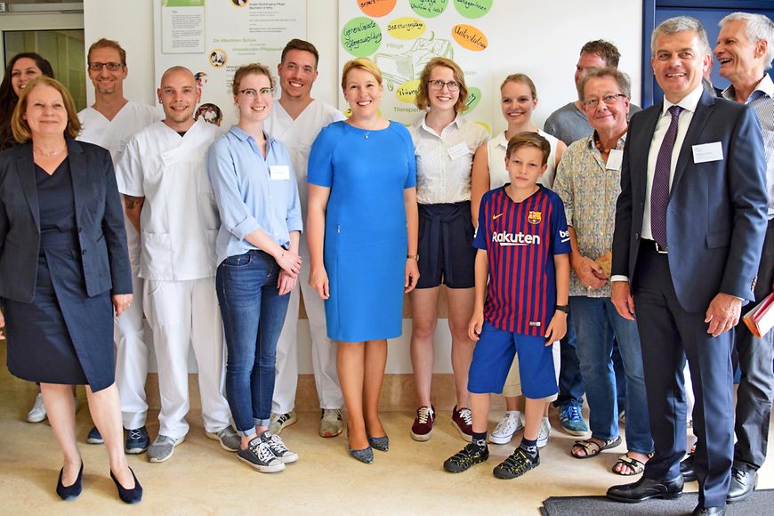 Ein Gruppenfoto in der Albertinen-Pflegeschule vor Plakaten mit den Aufschriften Ausbildung und Zukunftsvision