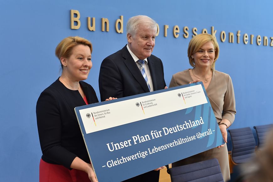 Dr. Franziska Giffey, Horst Seehofer und Julia Klöckner halten eine Tafel hoch mit der Aufschrift "Unser Plan für Deutschland"