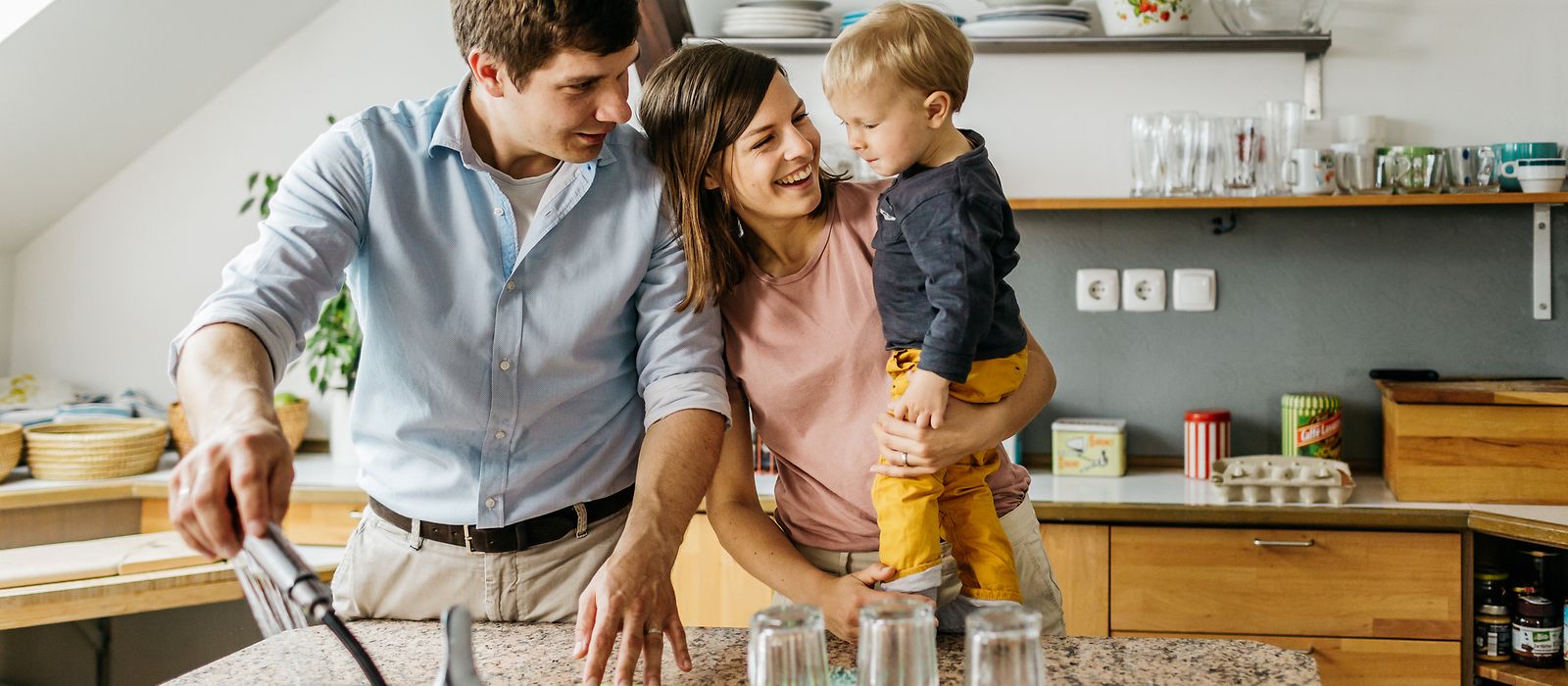 Eine junge Familie steht in der Küche beim Abwasch