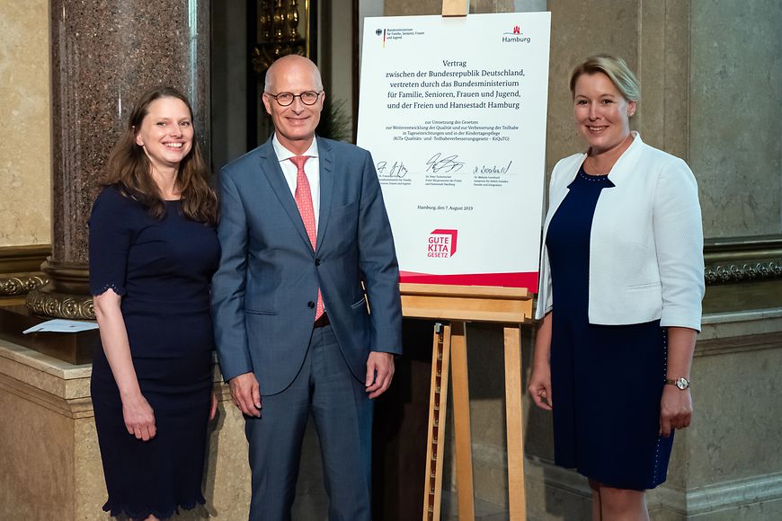 Bundesfamilienministerin Dr. Franziska Giffey steht zusammen mit zwei anderen Menschen vor einem Vertr