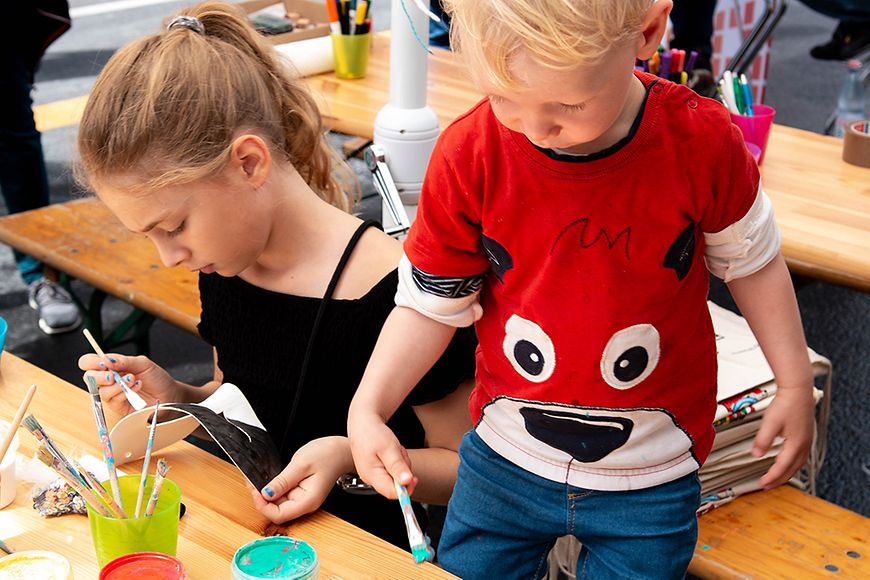 Kinder malen an Tischen