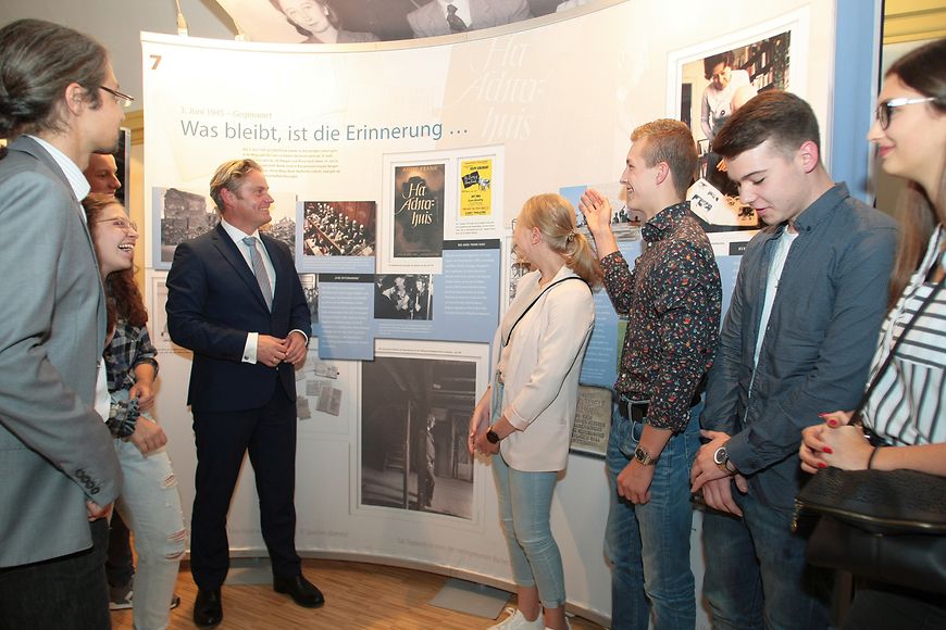 Stefan Zierke mit Jugendlichen vor einer Ausstellungstafel