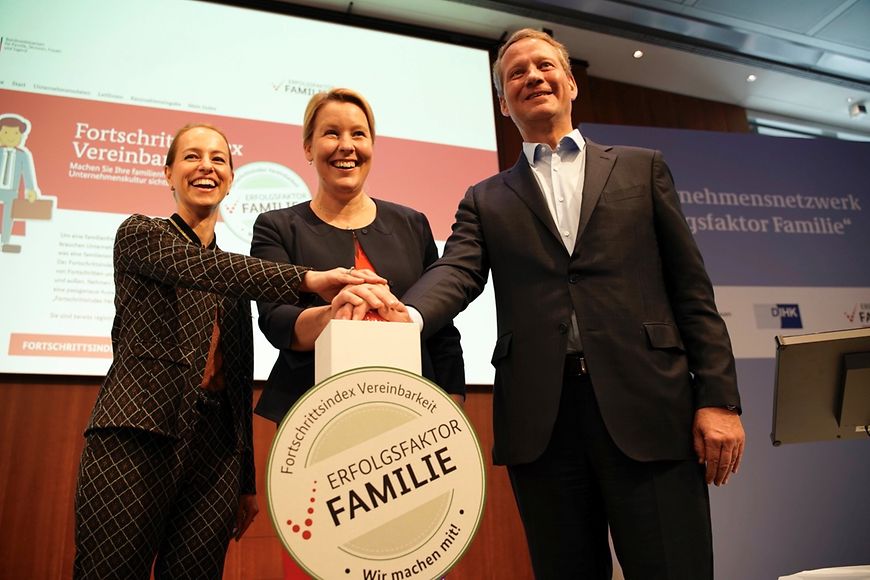 Drei Personen drücken auf einen Buzzer an dem steht: Erfolgsfaktor Familie, Fortschritssindex Vereinbarkeit