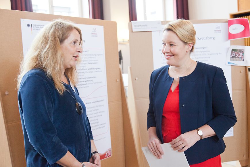 Dr. Franziska Giffey im Gespräch mit einer Frau vor Aufstellern mit Notizen zum Thema Elternbegleitung
