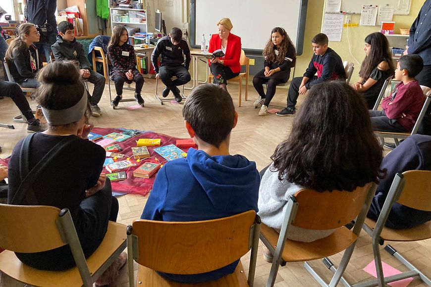 Dr. Franziska Giffey liest einer Gruppe von Kindern ein Buch vor